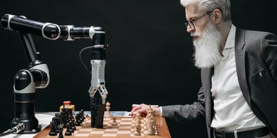 A man playing chess with a robot